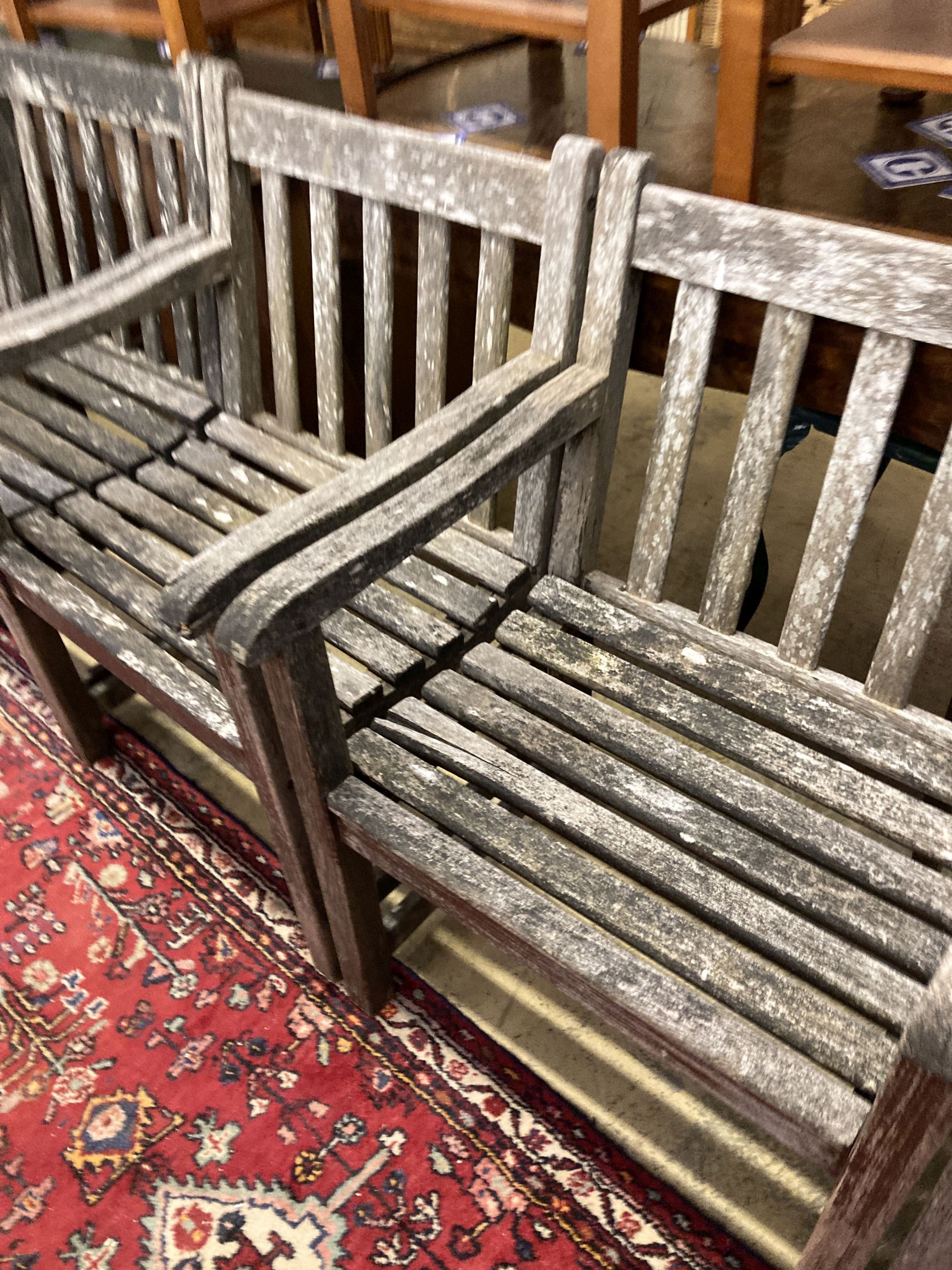 A set of six weathered teak elbow chairs, width 62cm, depth 58cm, height 85cm